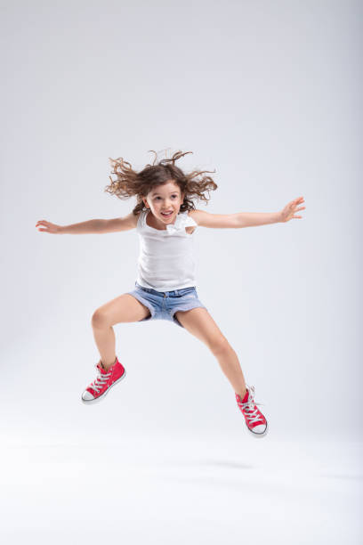 istock Hyperactive little girl leaping into the air 1166108830