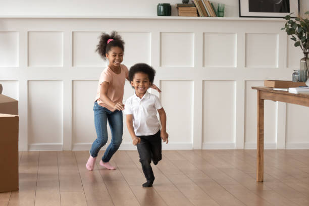 i bambini in età prescolare eccitati si divertono a correre a casa - child exercising little boys toddler foto e immagini stock