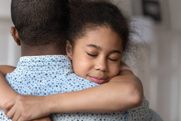 Happy little girl hug father showing love and care Close up of cute little black girl embrace african American dad have tender moment together show love and care, sensitive biracial kid daughter hug father happy to reunite after family separation mercy hug stock pictures, royalty-free photos & images