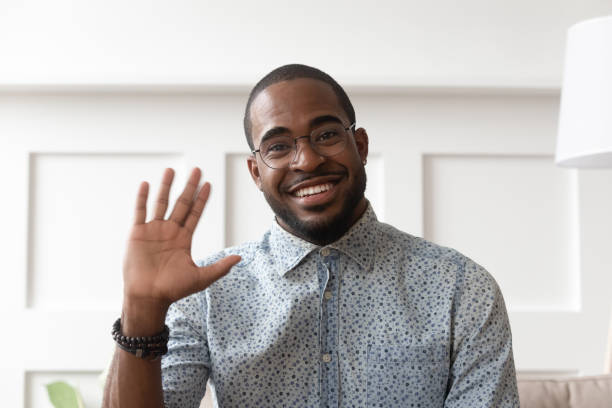 Smiling black man waving talking on video call