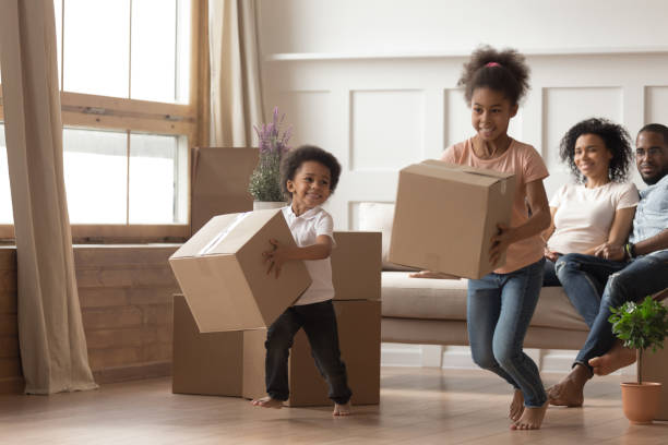 istock Playful small kids playing carrying boxes on moving day 1166111126