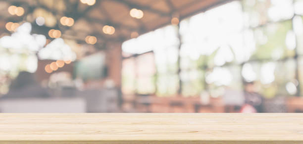istock Empty wooden table top with cafe restaurant or coffee shop window interior abstract blur defocused with bokeh light background for montage product display 1166111228