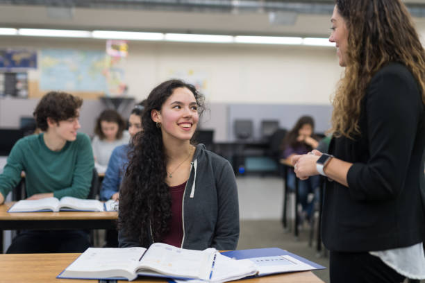 istock teacher helps high school student at her desk 1166116203