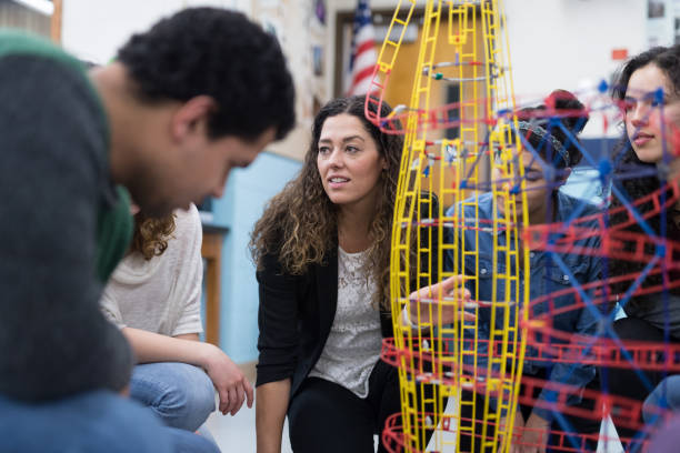 istock Ethnic art teacher shows her class a colorful example of sculpture 1166116285