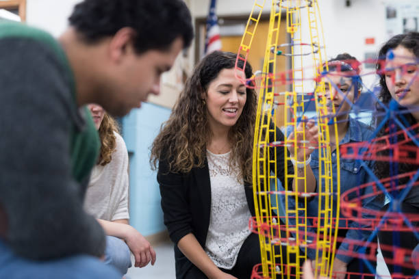 istock Ethnic art teacher shows her class a colorful example of sculpture 1166116333