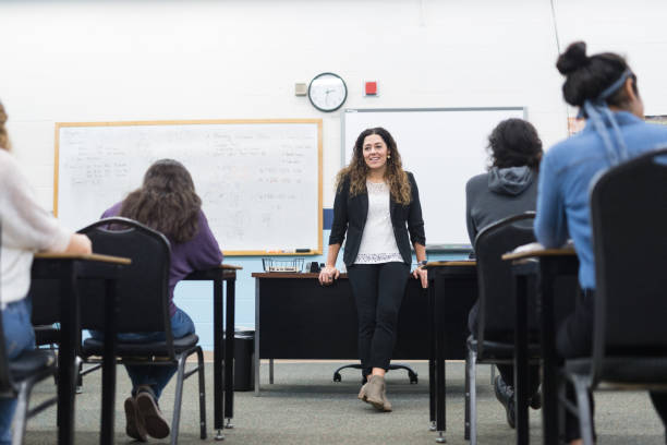 istock Ethnic teacher smiles while she waits to call on students with raised hands 1166117069