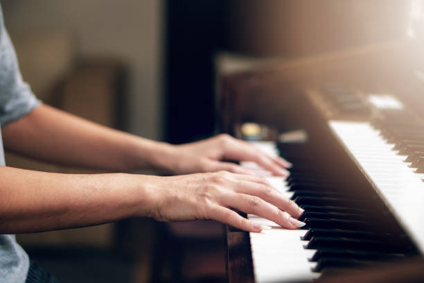 istock backgound of close up of hands playing piano 1166117250