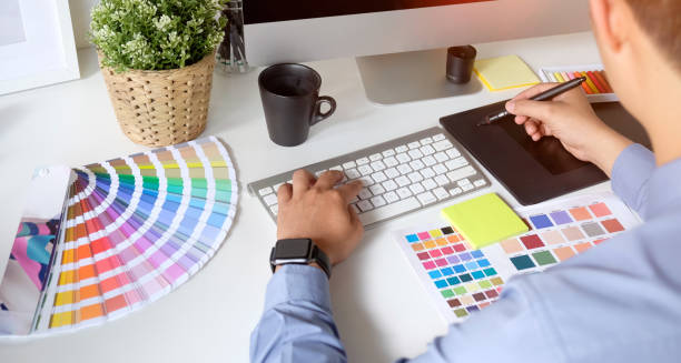 istock Graphic designer working with drawing tablet and colour swatches 1166124248