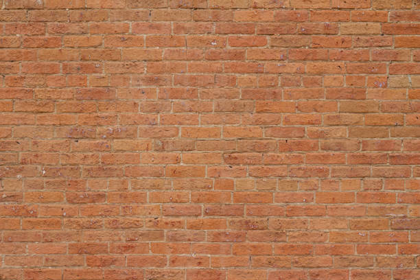 Antique reddish orange color brick wall background showing cracks and deterioration