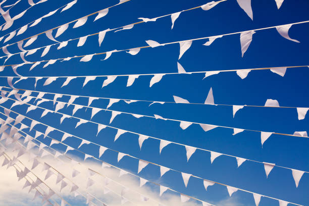 istock White flags waving in wind on navy blue sky background close up, banners flap on breeze, decorative garlands floats in the air, beautiful flags lines billowing, triangular flags flying in azure heaven 1166128483