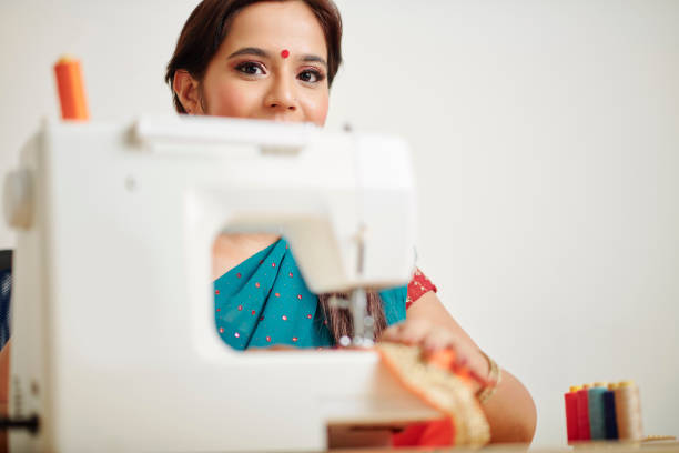 istock Cheerful woman sewing at home 1166129194
