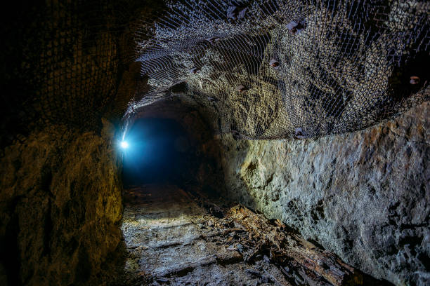 istock Dark dirty abandoned uranium mine with rusty remnants of railway 1166129921