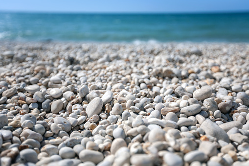 waves on mediterranean sea with pebble beach and green water