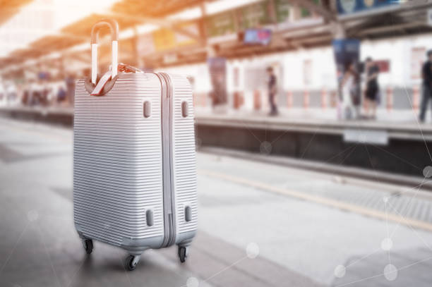 Sillver Suitcases or baggage at blurred of sky train station platform with network line for connected world wide of transport. Trip vacation or holiday tourism by bts city rail in Bangkok Thailand. stock photo