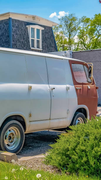 istock Vertical frame Old white van parked at the front yard of a home viewed on a sunny day 1166131951