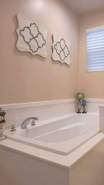 istock Vertical frame Bathroom interior with a polished built in bathtub and shower stall 1166136143