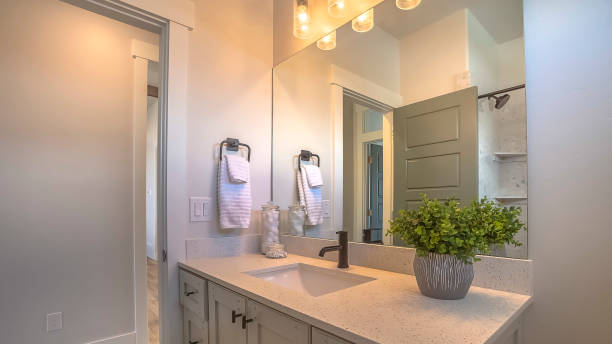 istock Panorama Mirror and vanity unit inside a bathroom with white wall and brown wood floor 1166136971