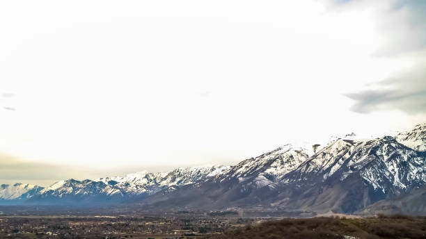 istock Panorama Blue sky filled with bright thick clouds over towering mountain and vast valley 1166137081