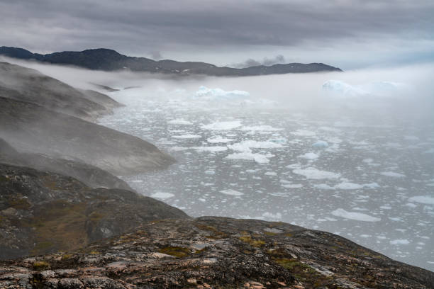 Icebergs at the end of the Ilulissat Icefjord in the Disko Bay in western Greenland at a foggy day.