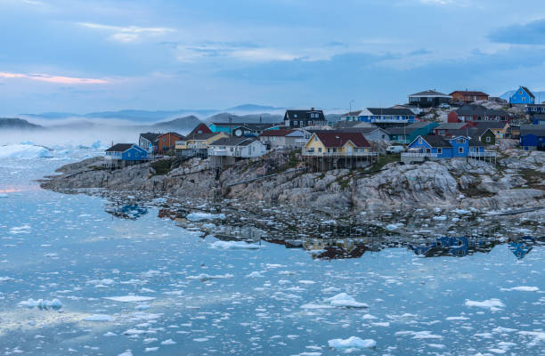 Ilulissat, Greenland View from the end of the Ilulissat Icefjord to the town Ilulissat at the Disko Bay in western Greenland at midnight in July. disko bay stock pictures, royalty-free photos & images