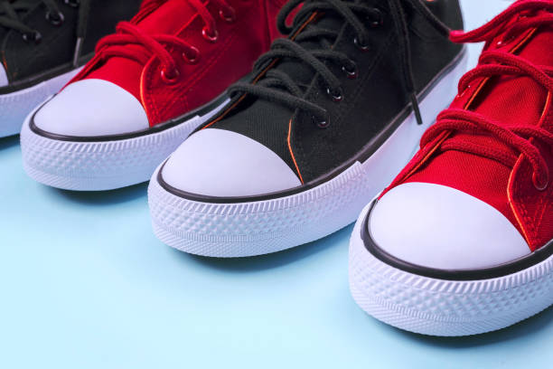 istock New black and red sneakers on pale blue background with copy space. 1166145745