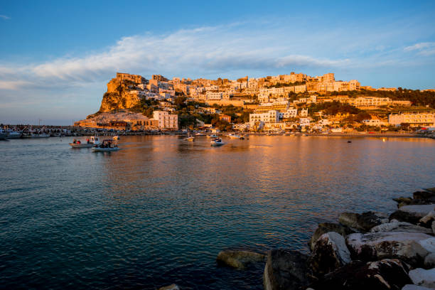 istock Setting sun lit city over the sea 1166149064