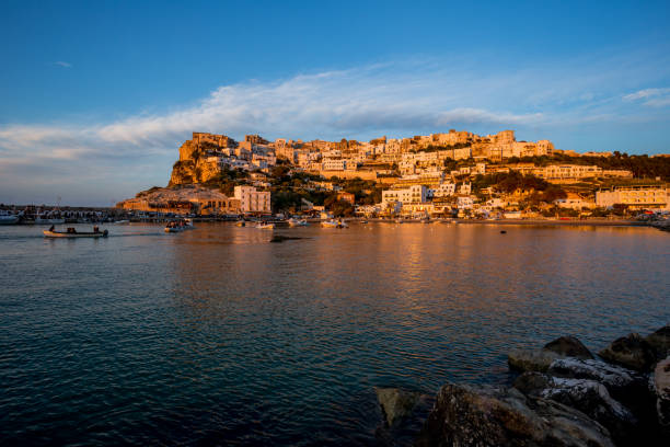 istock Setting sun lit city over the sea 1166149078
