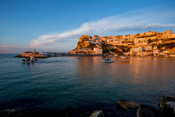 istock Setting sun lit city over the sea 1166149133
