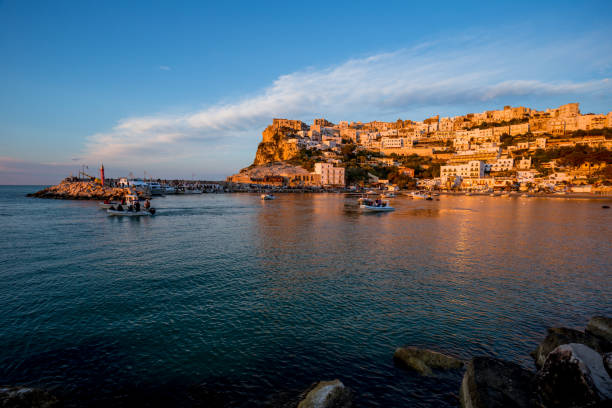 istock Setting sun lit city over the sea 1166149134