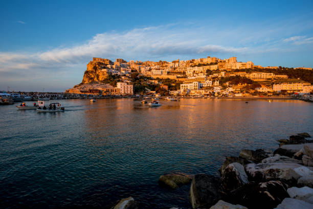 istock Setting sun lit city over the sea 1166149138