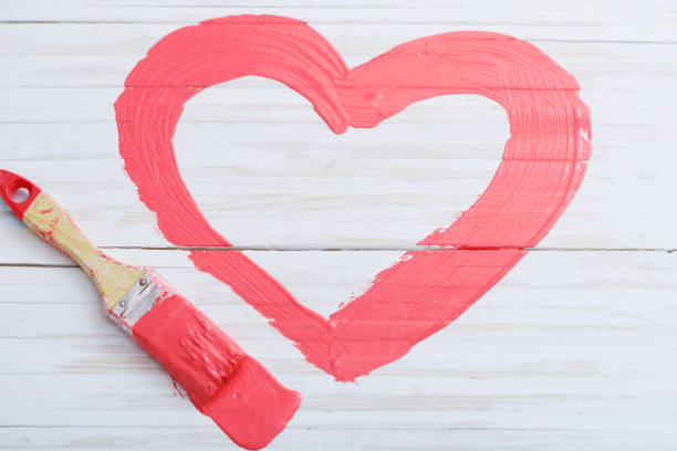 istock pink painted heart on white wooden background 1166152139