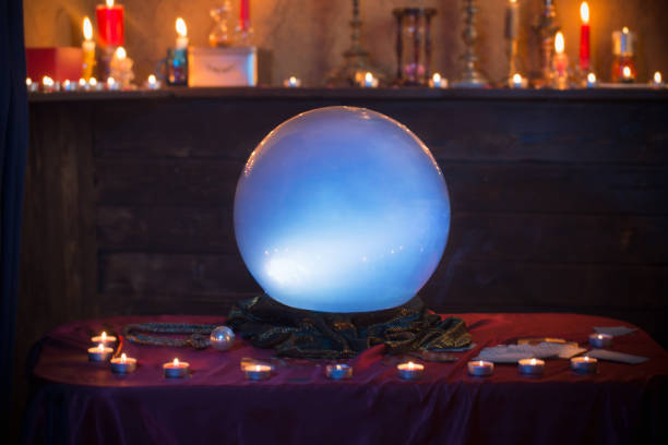 sfera di cristallo magica con candele accese sul tavolo - fortune teller immagine foto e immagini stock