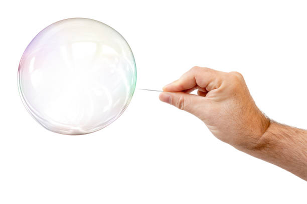istock soap bubble and a males hand with needle to let it pop 1166154113