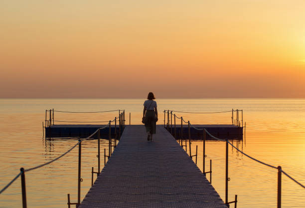 istock girl on pontoon pier at sunset 1166154924