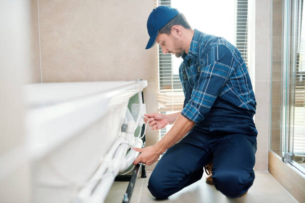 tecnico contemporaneo in abbigliamento da lavoro che installa il sistema di tubi con vasca da bagno - service occupation technology professional occupation installing foto e immagini stock