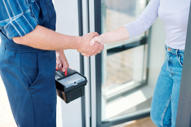 Young woman and technician saying goodbye while shaking hands after repair work Young woman and technician or plumber with toolbox saying goodbye while shaking hands after repair work door repairman men manual worker stock pictures, royalty-free photos & images
