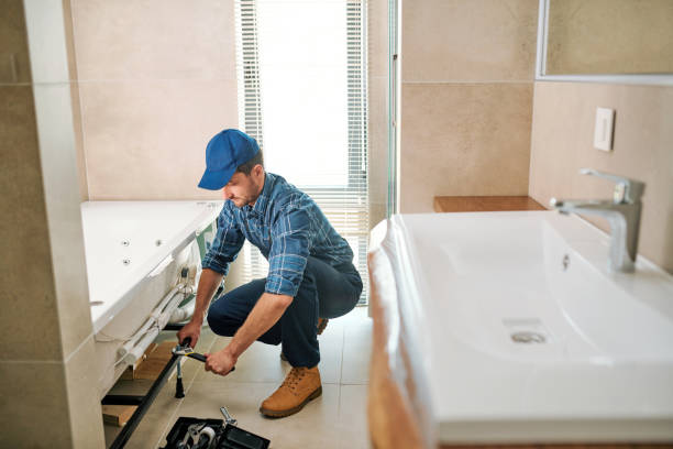 istock Young worker in uniform sitting on squats while fixing or fastening detail 1166155393