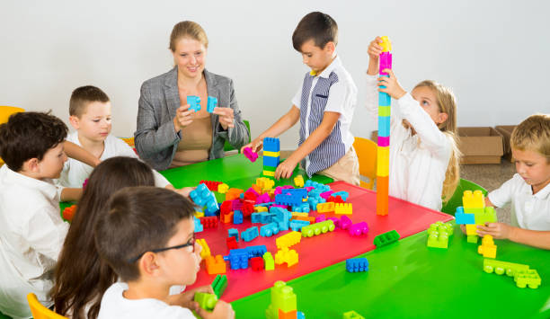 istock Kids and teacher playing with toy building blocks 1166156012