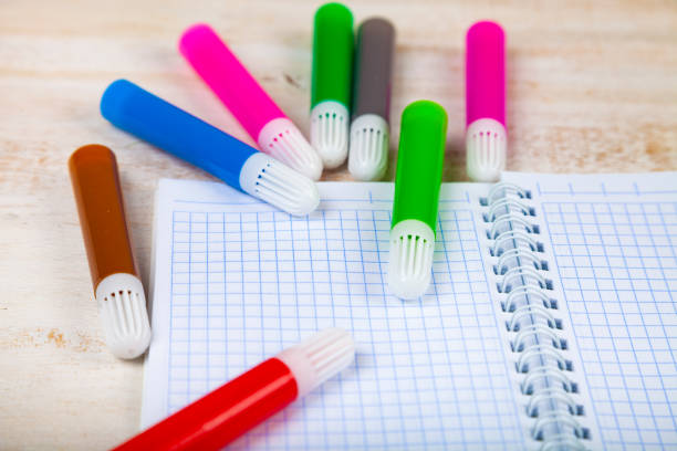 Back to school. Items for the school on a wooden table. Felt-tip pens and notebook.