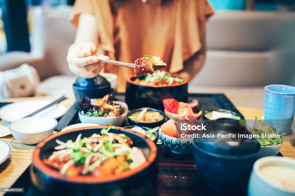 Young Asian woman enjoying Japanese food-eel rice. Women, Eating, Asia, Japan, Saltwater Eel,Food, Appetizer, Baked Restaurant Stock Photo