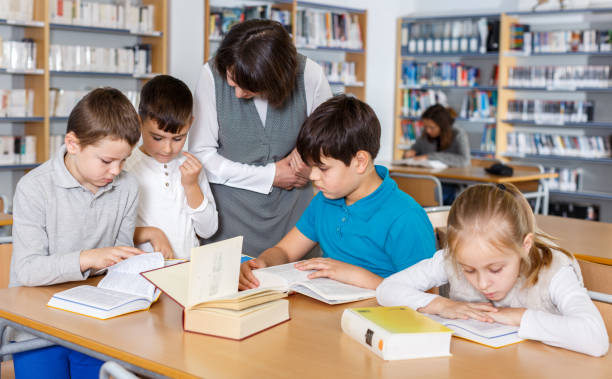 istock Female teacher and pupils working in classroom 1166158705