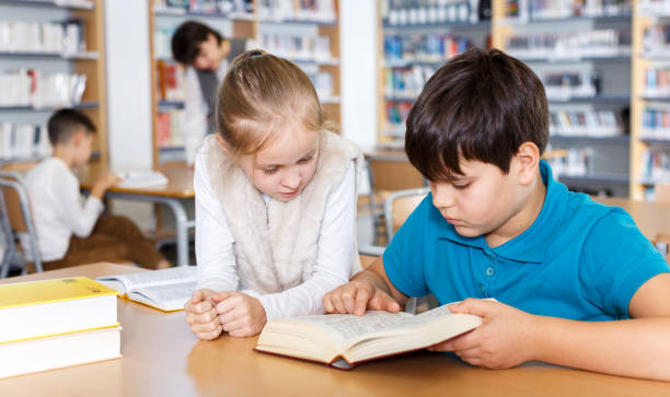 istock Girl and boy studying in school library 1166158707