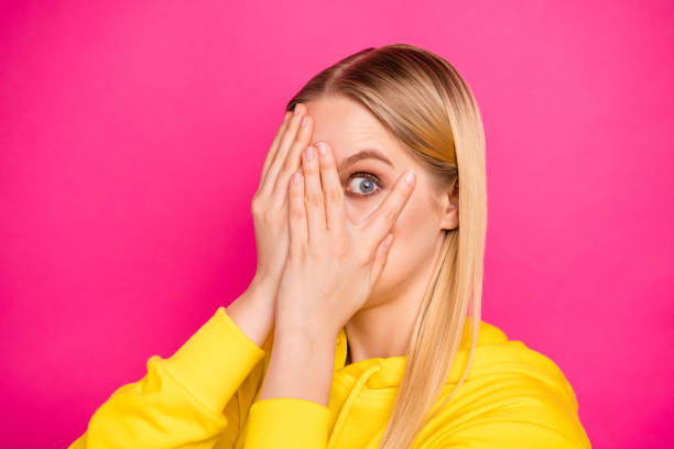 photo of pretty lady looking through arms on film screen wear yellow hoodie pullover isolated pink background - spy secrecy top secret mystery imagens e fotografias de stock