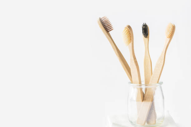istock Charcoal wooden bamboo toothbrushes in glass cup on white background. Zero waste plastic free eco friendly reusable materials for teeth hygiene health. Poster banner 1166161093