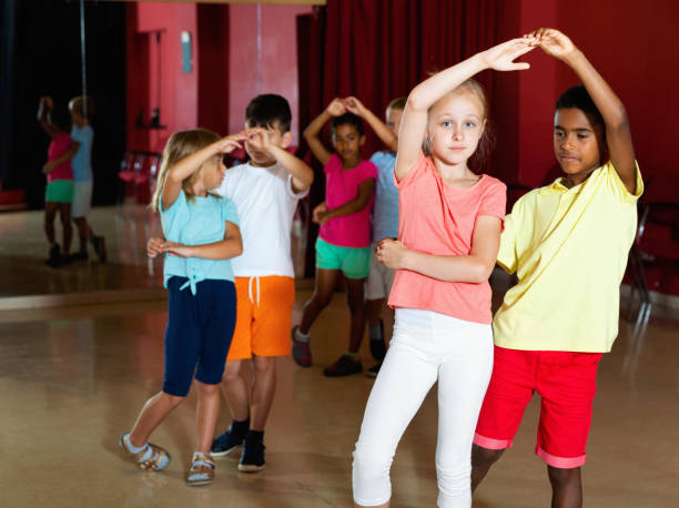 istock Smiling children primary school trying dancing salsa dance in modern studio 1166161384