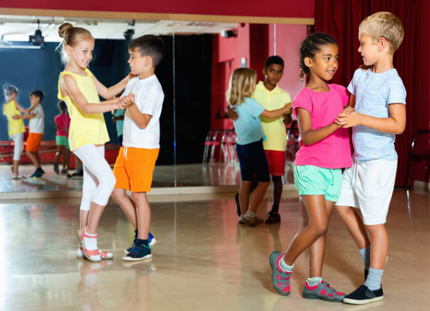 istock Group of positive childrens trying dancing with partner in classroom 1166161409