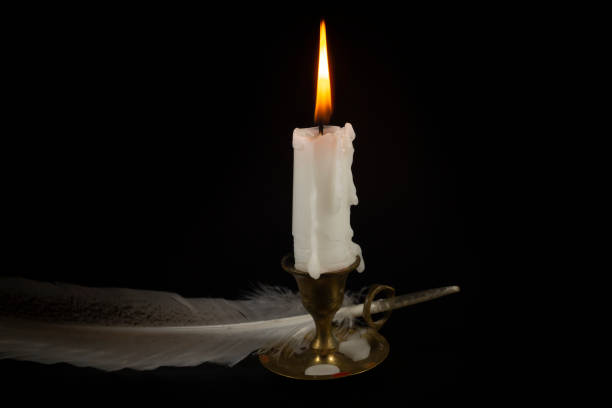 istock Burning candle in brass candlestick and quill pen 1166162720