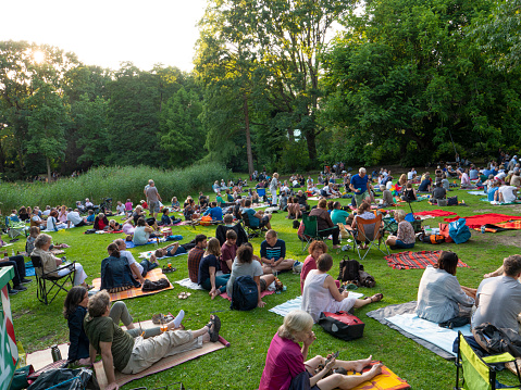 Berlin, Germany;People are lying in the grass and talking to each other in Tiergarten, Berlin. Every weekend in the summer people gather in the Tiergarten park for a picknick and listening to music.