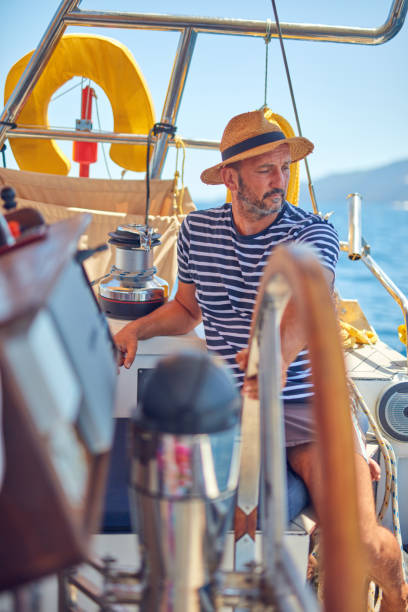 istock Sailor using wheel to steer rudder on a sailing boat. 1166163670