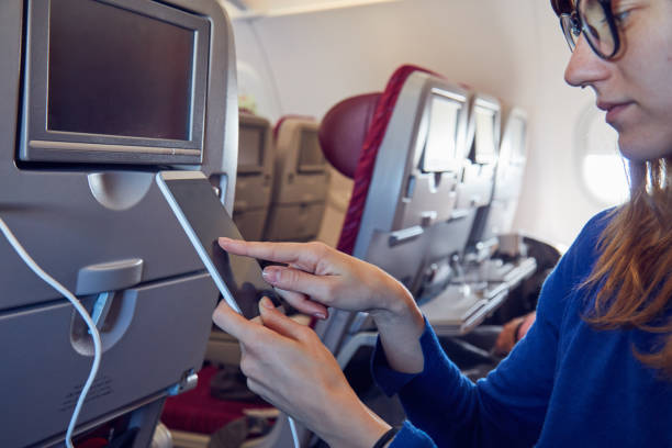 istock Woman using cellphone in modern airplane seat. 1166164393